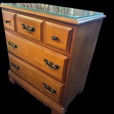 Sale Photo Thumbnail #227: 26"T × 24"W × 15"D Solid wood nightstand/chest featuring glass top cover  3 storage drawers with brass bail pulls  and bracket feet. Dimensions: 26" Tall x 24" Wide x 15" Deep.  