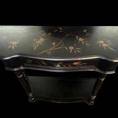 Sale Photo Thumbnail #256: 36"W × 12"D × 30.5"T Traditional demilune wall console table featuring a distressed black finish  hand-painted gold floral branch motifs across the top and single drawer front  turned fluted legs  and lower display shelf tier. Dimensions: 36" Wide x 12"