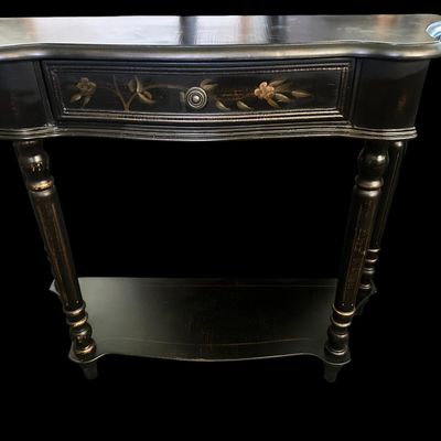 Sale Photo Thumbnail #254: 36"W × 12"D × 30.5"T Traditional demilune wall console table featuring a distressed black finish  hand-painted gold floral branch motifs across the top and single drawer front  turned fluted legs  and lower display shelf tier. Dimensions: 36" Wide x 12"