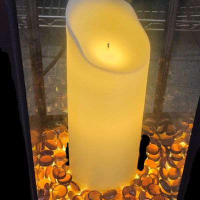 Sale Photo Thumbnail #368: Duraflame 28-inch heavy-duty infrared quartz electric lantern heater (Model AZ-82040 / 10ILH117 series) in a bronze finish. Features a 1400W/1500W infrared heating element (heats up to 1,000 sq ft), flickering LED pillar candle over amber glass rocks, tou