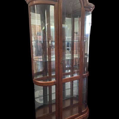 Sale Photo Thumbnail #477: 86"T × 44"W × 15"D Tall wood-framed curio cabinet with curved glass sides and arched top. Lighted interior with 5 glass shelves. Measurements: approx. 86" tall × 44" wide × 15" deep. Great for displaying collectibles. Local   in   / Shreveport area.  