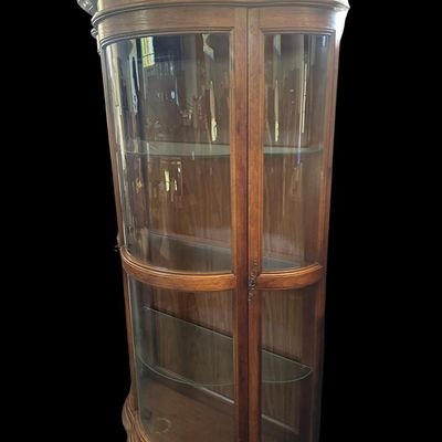 Sale Photo Thumbnail #499: 70 X 41 X 17 Serpentine curved glass front and sides  molded top cornice  wood frame  full glass display shelving  and brass pull handle.  