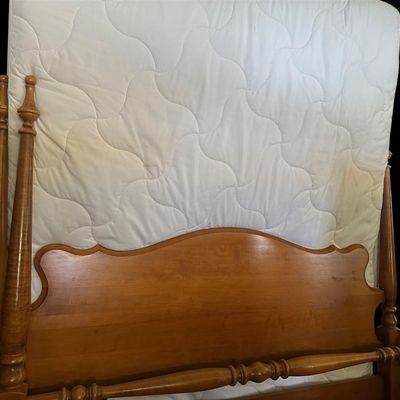 Sale Photo Thumbnail #520: Solid maple full size bed featuring four turned urn/cannonball corner posts  shaped arched headboard panel  turned spindle blanket rail  wooden side rails  and clean quilted mattress. 