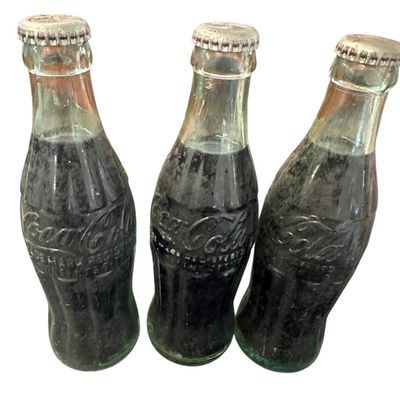 Sale Photo Thumbnail #863:  Three capped / still-full 6.5 oz Coca-Cola bottles. Two Monroe  one Shreveport. Do not wash. Collectible  not for drinking.