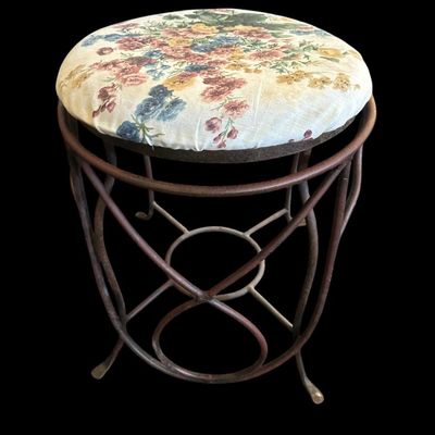 Sale Photo Thumbnail #940: Round vanity stool featuring a dark metal base with looping wire scrollwork  stretcher ring support  and padded floral chintz fabric seat cushion.  