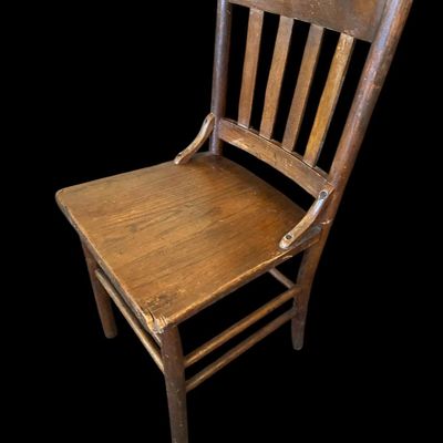 Sale Photo Thumbnail #944: Antique solid oak side chair featuring top crest rail  vertical back slats  side support brackets  and solid wood seat with age patina.  