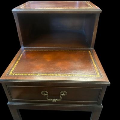 Sale Photo Thumbnail #963: 25.50 x 17.75 x 29.00 Traditional two-tier step-down end table featuring gold-embossed leather top surfaces  open middle cubby bay  lower drawer with brass swan-neck pull handle  and dovetail joinery 25.50 x 17.75 x 29.00  
