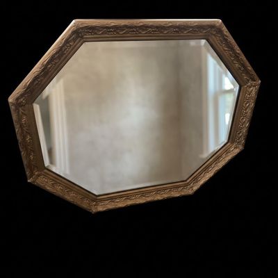 Sale Photo Thumbnail #984: Octagonal wall mirror framed in a molded antique gold metallic casing featuring continuous floral leaf scroll details.  