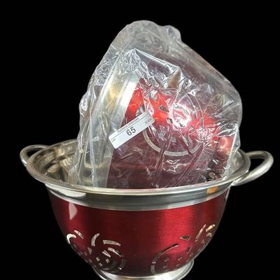 Sale Photo Thumbnail #994:  Two Stainless Steel Colanders with Red Exterior and Apple Cutout Design.                           