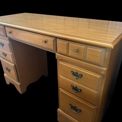 Sale Photo Thumbnail #1073: 30 X 44 X 17.50 Traditional Maple Double Pedestal Executive Kneehole Desk  features 7 drawers total with center pencil drawer flanked by storage drawers and deep lower file drawers  molded top border  scalloped apron base  and brass drop-pull hardware. 30