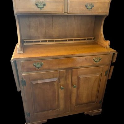 Sale Photo Thumbnail #1077: 53"T × 18"D × 38"W (down) / 62"W (up) Upper hutch with spindle gallery top rail and dual small drawers; main cabinet features drop-leaf sides  single wide drawer over double cabinet doors  and antique brass batwing bail handles. Dimensions: 53" H x 18" 