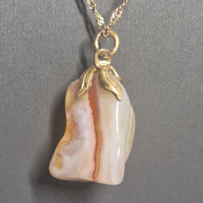 Sale Photo Thumbnail #24: Natural Agate / Rhodite Pendant on 14k ITALY gold chain & Earrings + Bracelet
The image shows a natural agate gemstone pendant with a smooth, polished surface and a banded pink or reddish stripe
.< Necklace is 14K marked Italy. 18" long full length w/ lob