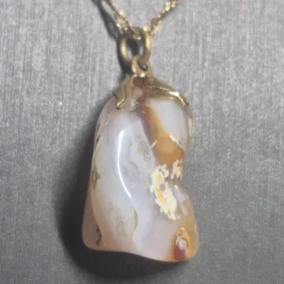Sale Photo Thumbnail #25: Natural Agate / Rhodite Pendant on 14k ITALY gold chain & Earrings + Bracelet
The image shows a natural agate gemstone pendant with a smooth, polished surface and a banded pink or reddish stripe
.< Necklace is 14K marked Italy. 18" long full length w/ lob