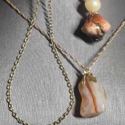 Sale Photo Thumbnail #26: Natural Agate / Rhodite Pendant on 14k ITALY gold chain & Earrings + Bracelet
The image shows a natural agate gemstone pendant with a smooth, polished surface and a banded pink or reddish stripe
.< Necklace is 14K marked Italy. 18" long full length w/ lob
