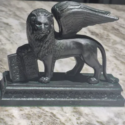 Sale Photo Thumbnail #6: Vintage neoclassical spelt sculpture of the winged lion of Saint Mark
vintage patinated  statue depicting the winged lion of Saint Mark, the the emblem of Venice, Italy.
The statue is likely a grand tour souvenir, very popular in the 19th and early 20th c