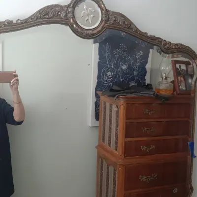 Large vintage wall mirror with an ornate carved frame and etched top medallion.