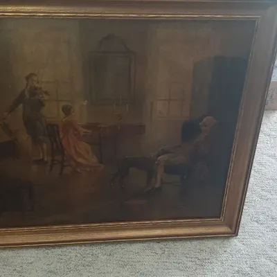 Framed classical interior scene print depicting figures gathered in a dimly lit parlor, housed in a molded gilt wood frame.