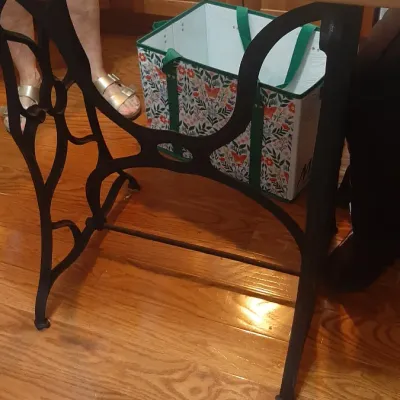 Vintage-style table crafted with cast iron treadle sewing machine legs and a light wood top.