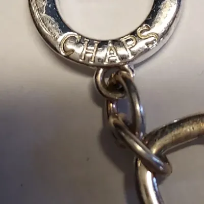 Sale Photo Thumbnail #231: This Chaps bracelet features a sleek and stylish link chain design with a toggle closure. The bracelet is made of metal material with a silvertone finish, and is signed by the brand. With a length of 7.7 inches, this bracelet is suitable for any occasion 