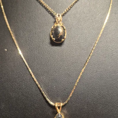 Sale Photo Thumbnail #261: Vintage Gold tone Set ~ 2 Necklaces & 2 Fashion Brooches
> necklace marked STC Karis w/ black n gold flake stone
> necklace with elongated pendant is 18" long w/lobster clasp
> 2 brooches .....pin perfect 
all in Vg condition