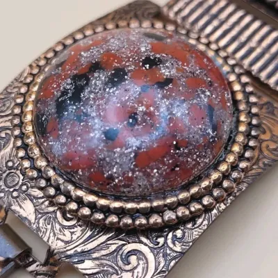 Sale Photo Thumbnail #275: This Vintage Natural Patina Copper & Red Confetti Lucite Cabochon Panel Bracelet features a unique design with simulated red cabochon stones set in copper. Measuring 7 inches in length,
excellent condition, cleaned and toned to luster