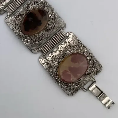 Sale Photo Thumbnail #274: This Vintage Natural Patina Copper & Red Confetti Lucite Cabochon Panel Bracelet features a unique design with simulated red cabochon stones set in copper. Measuring 7 inches in length,
excellent condition, cleaned and toned to luster