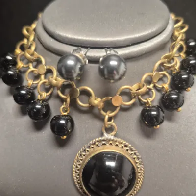 Sale Photo Thumbnail #131: Vintage dangling large Black Cabochon glass stone and dangling black beads on a 8" brass-tone chain bracelet.
> Monet marked 15" glass bead necklace w/ lobster clasp
> pair of stuff earring to coordinate