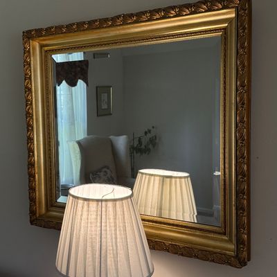Large rectangular wall mirror in a gilded wood frame with ornate leaf moulding