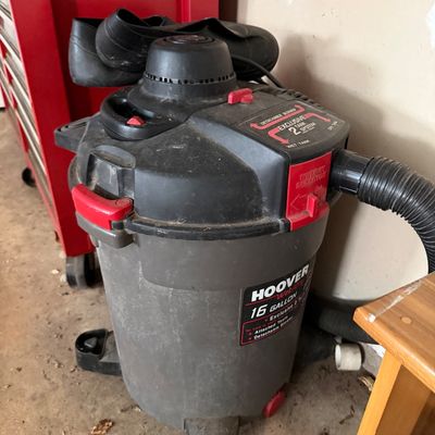 Hoover 16-gallon wet/dry vacuum with detachable blower, featuring a two-tank system and flexible hose attachment.