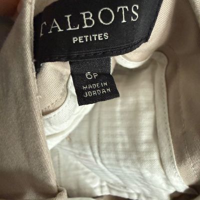 Close-up of a Talbots Petites clothing label on beige pants, size 6P, 