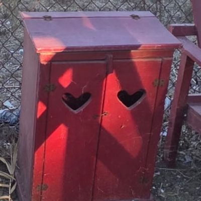 Sale Photo Thumbnail #34: Rustic red painted wooden cabinet featuring heart-shaped cutouts on the double cabinet doors and a lift-top lid.