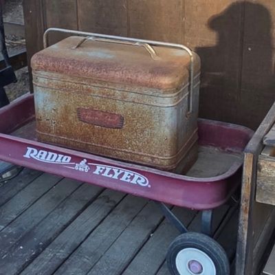 Sale Photo Thumbnail #36: Vintage metal Therm-a-Chest cooler sitting inside a red Radio Flyer wagon, both showing heavy patina and rust.