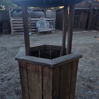 Sale Photo Thumbnail #38: Rustic wooden decorative wishing well structure with a conical roof and hexagonal base, suitable for garden or yard display.