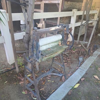 Sale Photo Thumbnail #40: Antique cast iron clothes wringer with hand-crank mechanism and wooden rollers, showing significant wear and weathering from outdoor display.