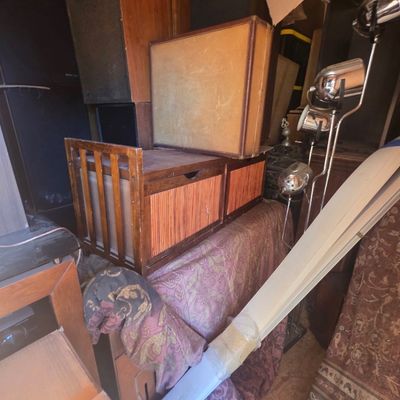 Sale Photo Thumbnail #41: Storage unit tightly packed with assorted household items, including a chrome multi-light floor lamp, wooden furniture, rolled textiles, and vintage audio equipment.