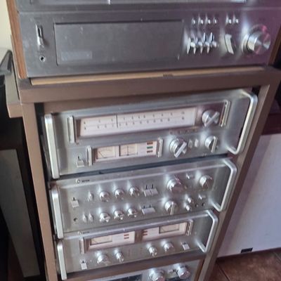 Sale Photo Thumbnail #52: Vintage stereo component stack housed in a rolling rack, featuring silver-face receivers and tuners from brands like Toshiba and Setton, circa late 1970s.