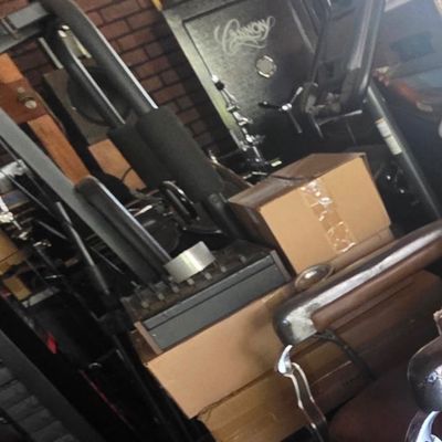 Sale Photo Thumbnail #57: A large black Cannon gun safe surrounded by fitness equipment, cardboard boxes, and vintage decor items.