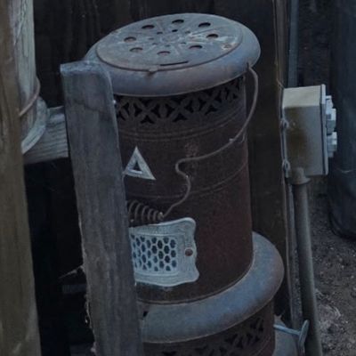 Sale Photo Thumbnail #63: Vintage Perfection kerosene space heater with a rusted patina and ornate metalwork.