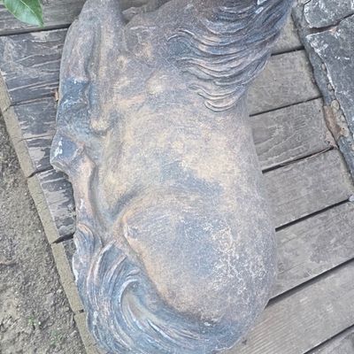 Sale Photo Thumbnail #68: Weathered concrete or cast stone garden statue of a recumbent horse, showing natural distress and surface wear.