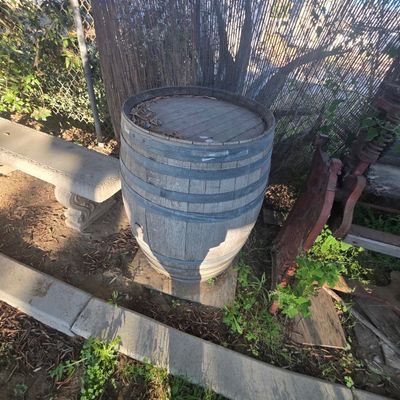 Sale Photo Thumbnail #73: Rustic weathered oak wine or whiskey barrel with metal hoops, suitable for garden decor or a patio table.