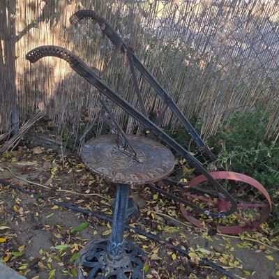 Sale Photo Thumbnail #74: Vintage cast metal sundial on a pedestal next to a weathered antique manual farm cultivator or walk-behind plow.