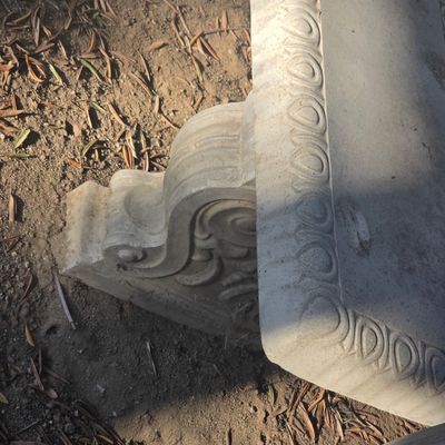 Sale Photo Thumbnail #78: Cast stone or concrete garden bench featuring detailed scrollwork supports and an egg-and-dart patterned trim along the curved seat.