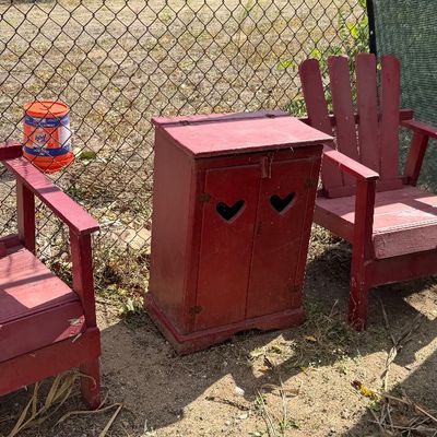 Sale Photo Thumbnail #88: Set of rustic painted red wooden lawn furniture, including two Adirondack-style armchairs and a small cabinet with heart cutouts.