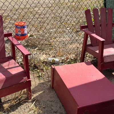 Sale Photo Thumbnail #93: Set of two red-painted wooden Adirondack chairs with a matching small rectangular side table, showing weathered paint and outdoor wear.
