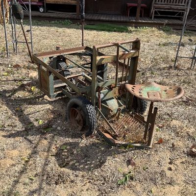 Sale Photo Thumbnail #99: Vintage handmade metal utility cart with a tractor seat attachment, showing heavy rust and weathering from outdoor display.