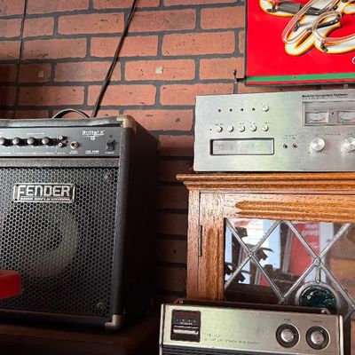 Sale Photo Thumbnail #143: Fender Rumble 15 bass combo amplifier alongside vintage stereo audio components, including a Modular Component Systems receiver.