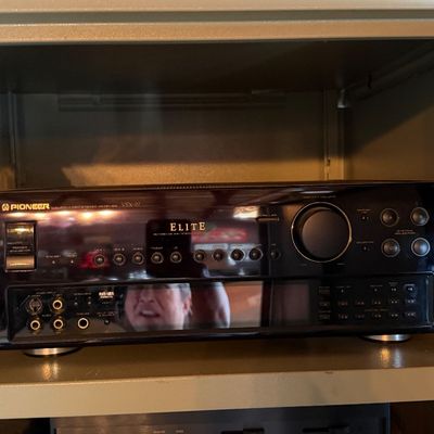 Sale Photo Thumbnail #158: Pioneer Elite audio/video multi-channel receiver sitting above a vintage Marantz Model 105 stereophonic tuner on shelf display.