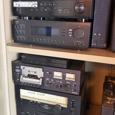 Sale Photo Thumbnail #161: Shelved vintage home audio equipment, including a Sansui AU-517 integrated amplifier, TU-517 tuner, cassette deck, and modern AV receivers by Yamaha, Adcom, and Toshiba.