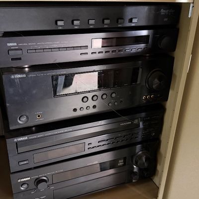 Sale Photo Thumbnail #173: Stack of vintage Yamaha audio components, including Natural Sound receivers, tuners, and a compact disc player, housed inside a cabinet.
