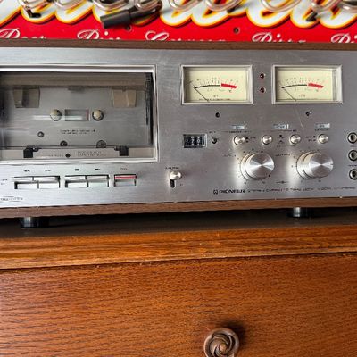Sale Photo Thumbnail #175: Vintage Pioneer CT-F700 stereo cassette tape deck featuring dual VU meters and a silver faceplate in a wood cabinet, circa late 1970s.